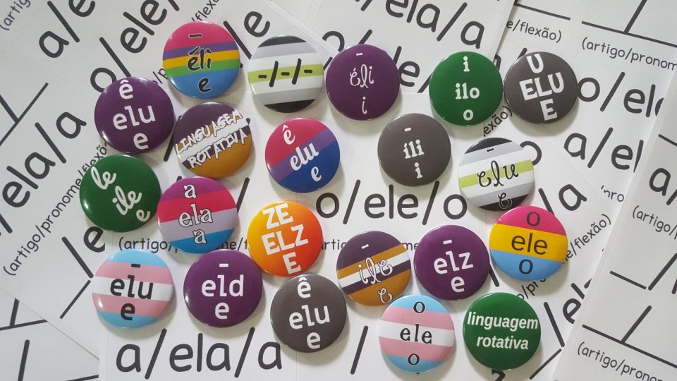 Buttons contendo diversos conjuntos de linguagem por cima de uma série de folhas de adesivos que também contém diversos conjuntos de linguagem.